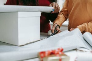 person wrapping a christmas present